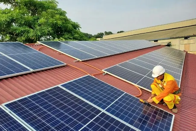 A professional installing solar panels on a roof.