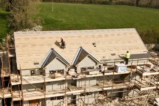 Roofers assembling a modular roof.