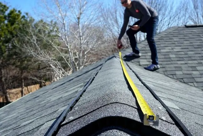 man measuring roof for step flashing